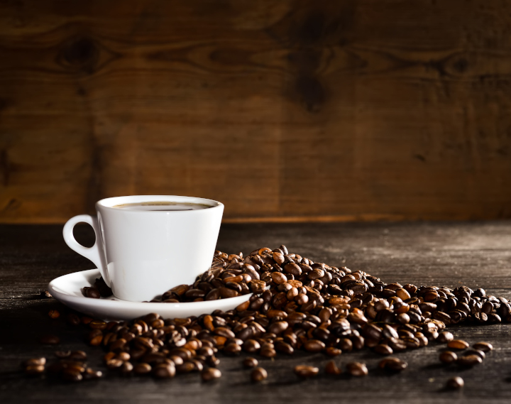 fresh-coffee-beans-with-a-cup-of-coffee-on-the-table